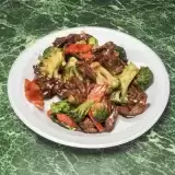 Beef with Broccoli in a plate on green background