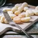 Front shot of uncooked Homemade Vegan Gnocchi un a wooden board