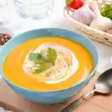 Front shot of Vegan Pumpkin Soup in a bowl with spoon on the side