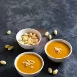 Front shot of Peanut Dipping Sauce in saucers with peanuts on the side