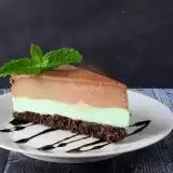 Sideview of a slice of milk chocolate cheesecake on a plate 