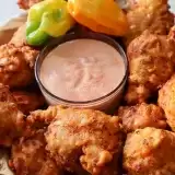 Bahamian conch fritters with dipping sauce in the middle