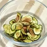 Side view of air fryer zucchini chips in a glass bowl 