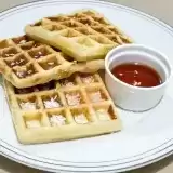 Side view of three coconut waffles on a plate