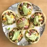 Overview of a platter of six colorful black bean tostadas